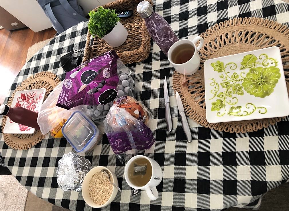 Gedeckter Frühstückstisch mit Tee, Bagels und Trauben